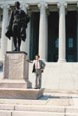 米財務省アレキサンダー・ハミルトン像の横で